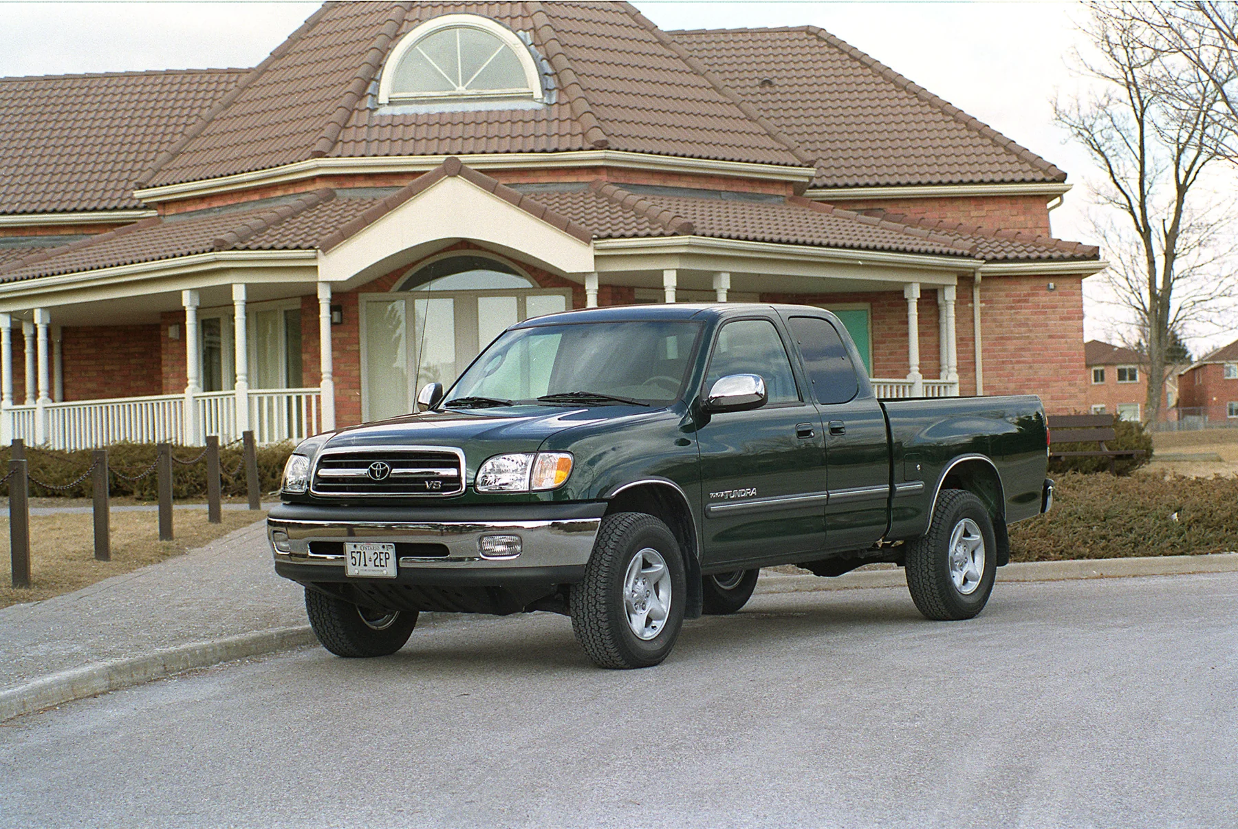 Green 2000 Toyota Tundra Access Cab on a street in front of a house.