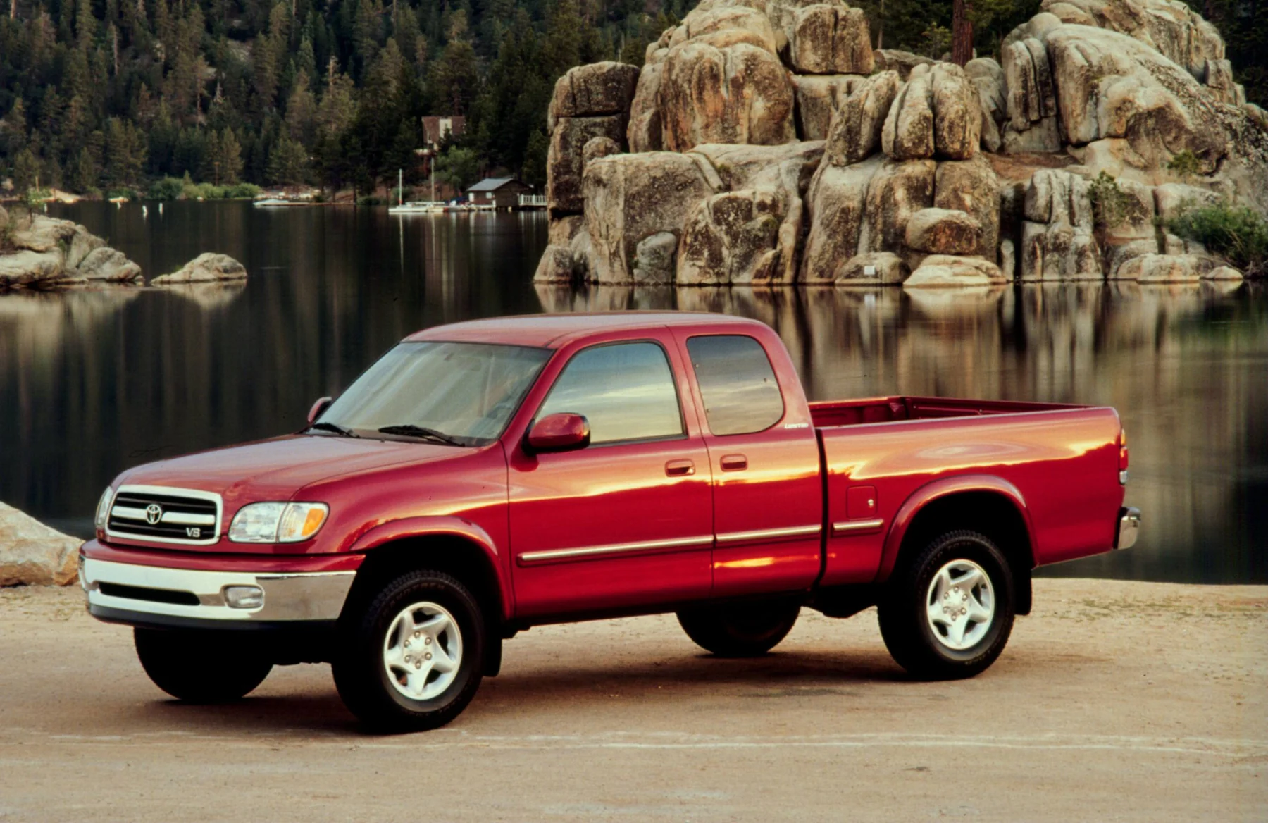 Red 2000 Toyota Tundra Access Cab beside a rocky pond.